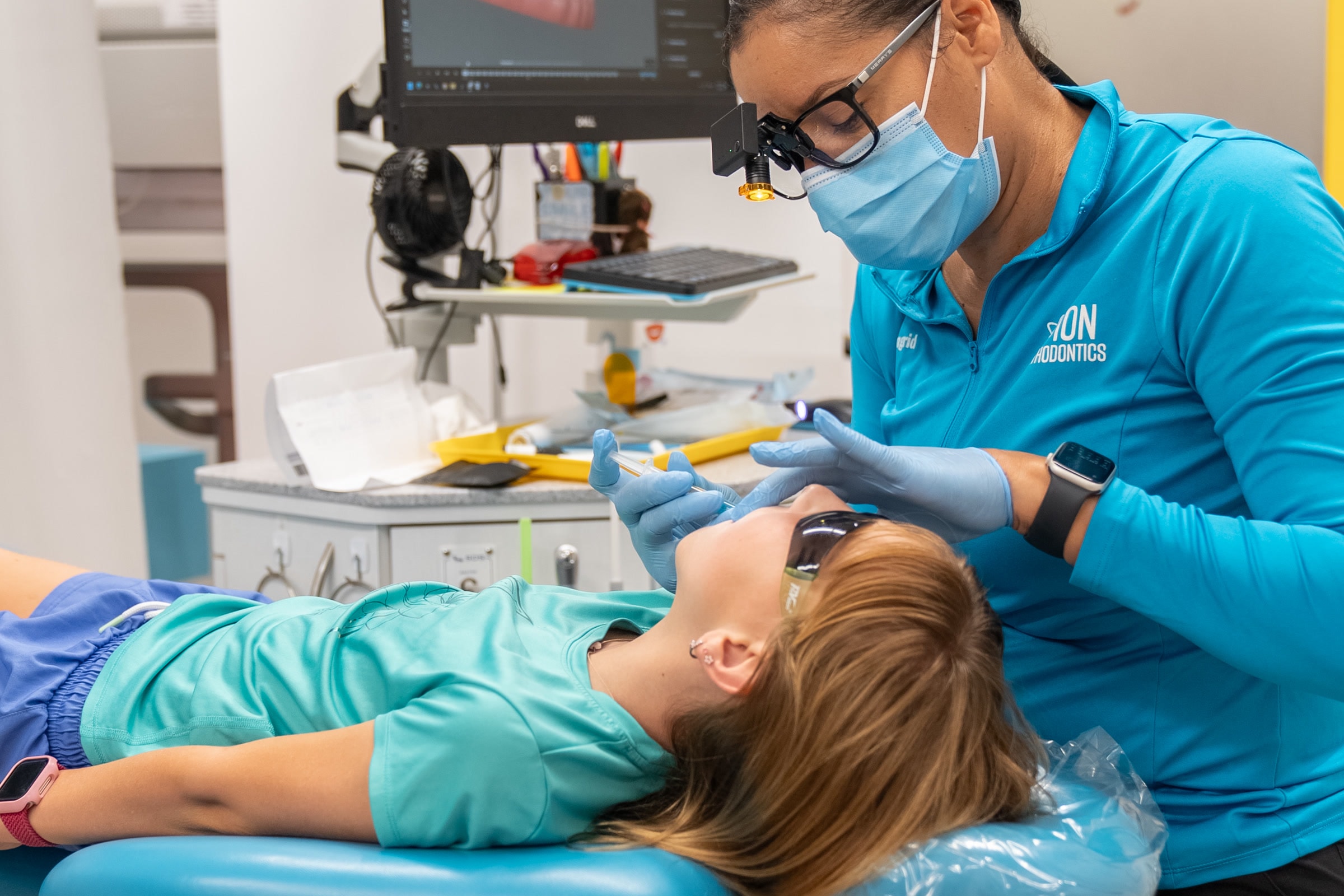 Un profesional y un paciente joven revisan una radiografía panorámica en tratamiento temprano en ION Orthodontics en Port St. Lucie